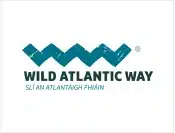Logo for the Wild Atlantic Way featuring a blue zigzag wave above the text “WILD ATLANTIC WAY” and the Irish translation “SLÍ AN ATLANTAIGH FHÁIN” on a white background.